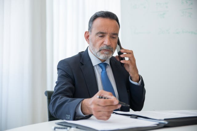 person speaking on the phone while sitting at their desk